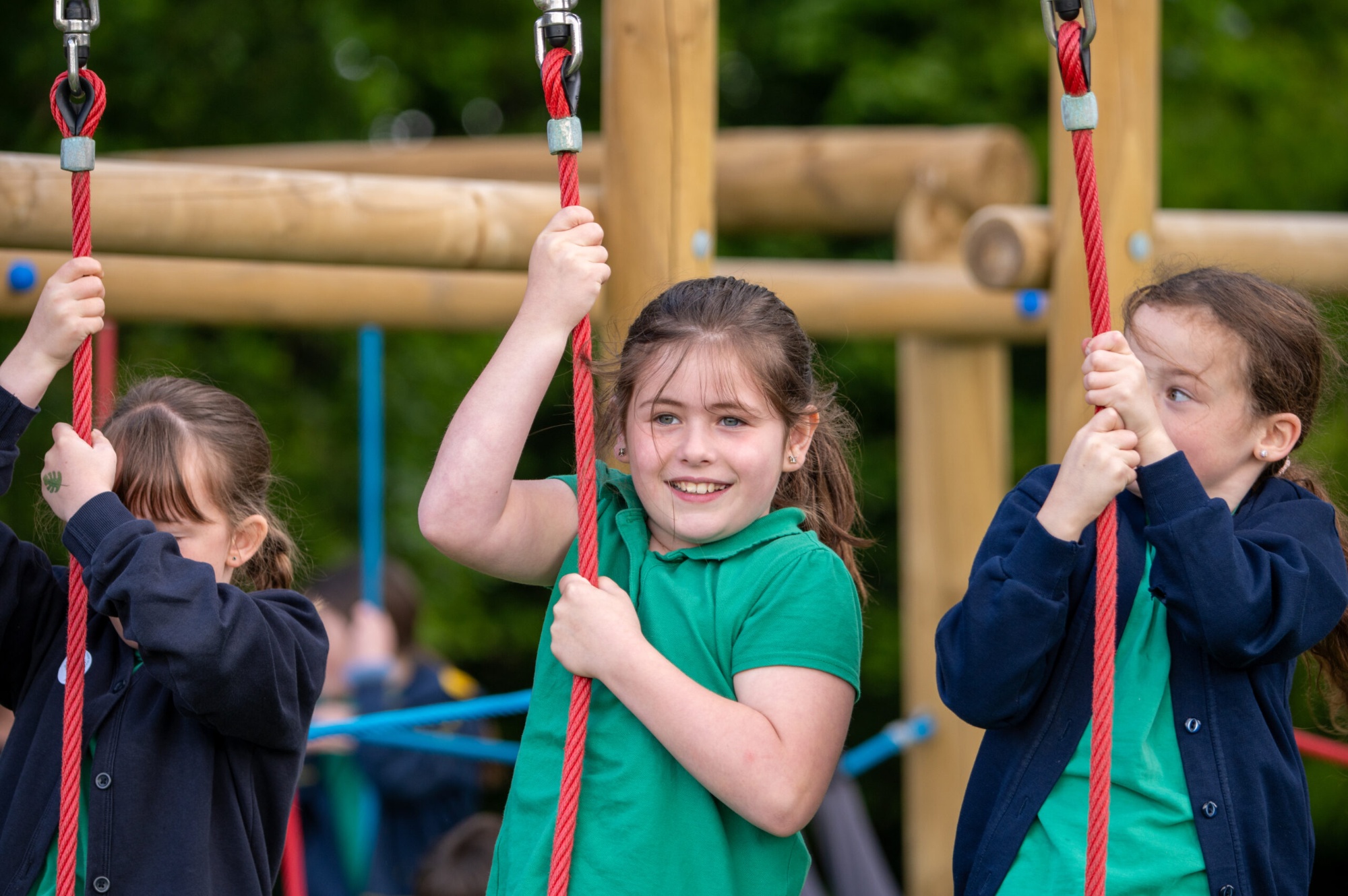 Children playing on the swings smiling